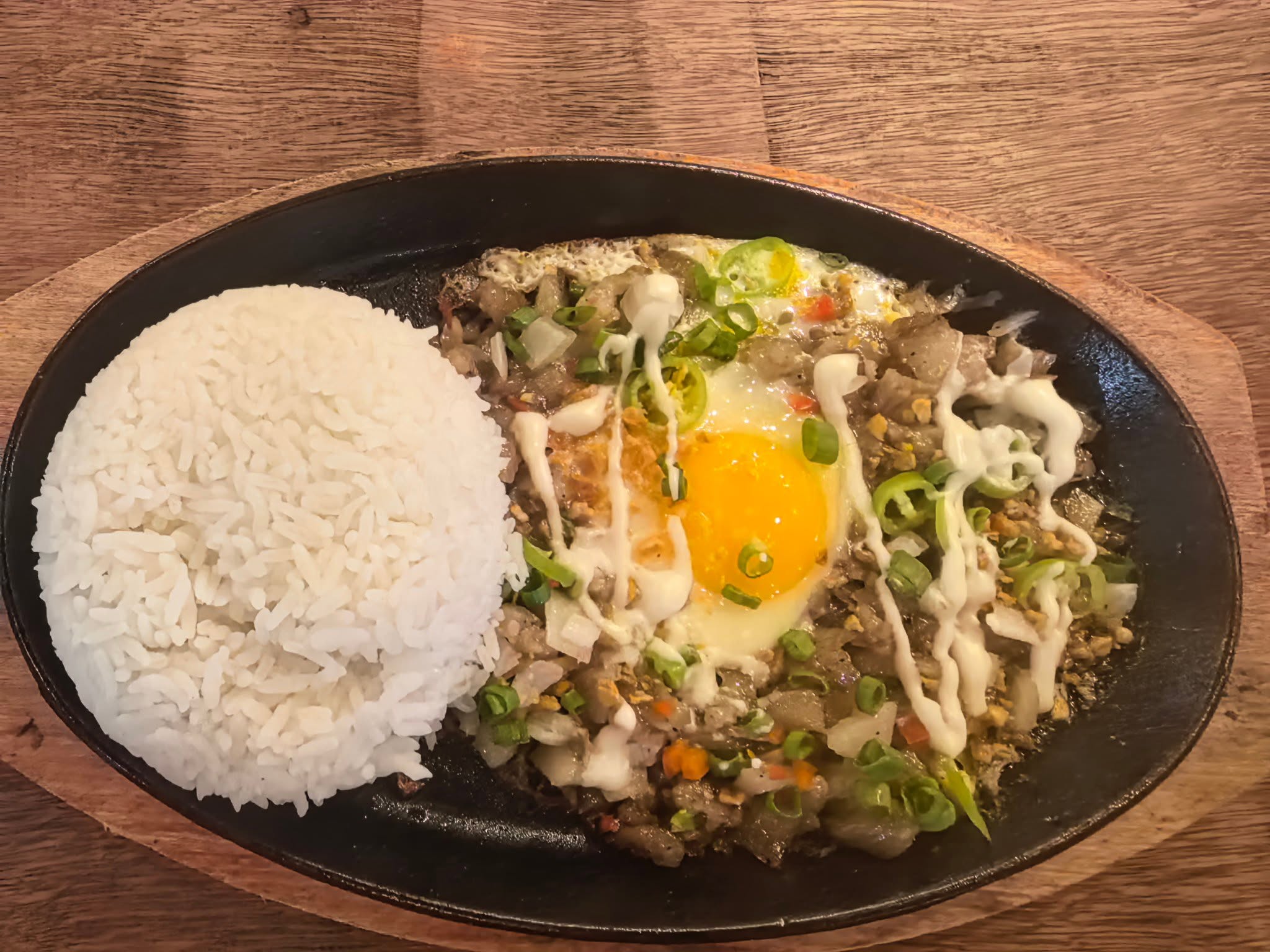 Rice and a sizzling dish topped with egg photographed at D’ Garden at Calatao