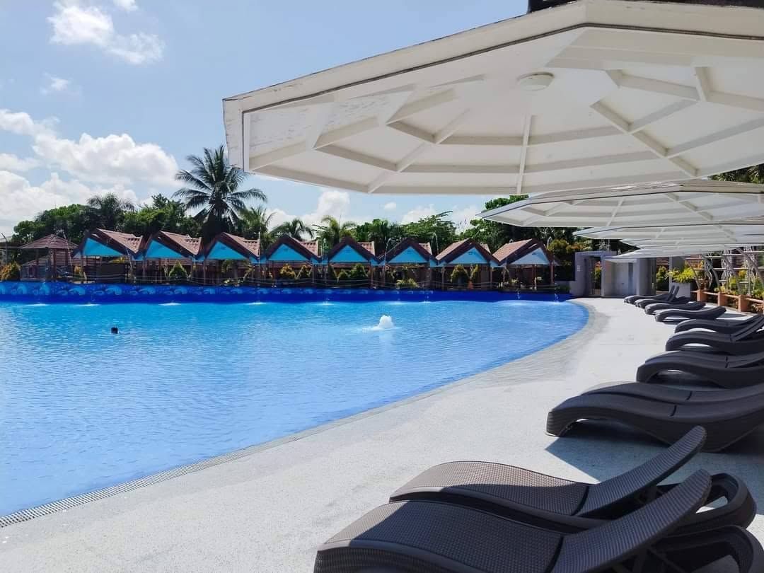 Large wave pool with shaded loungers and poolside cottages