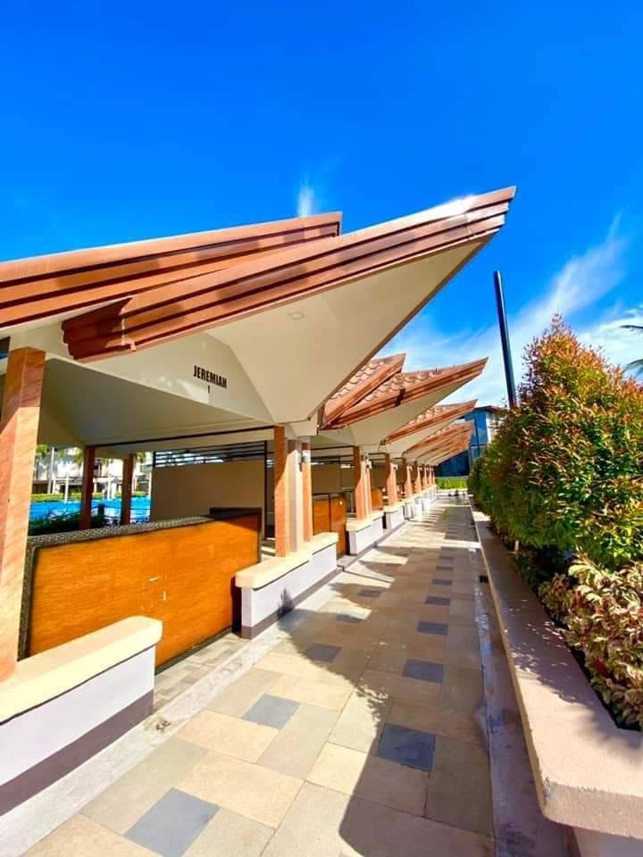 Covered poolside cottages along a sunny resort walkway