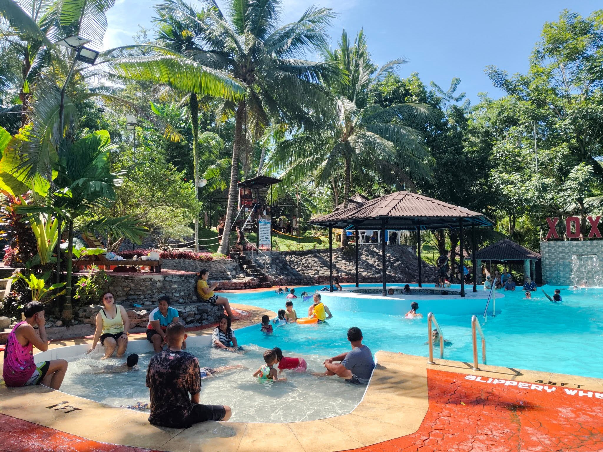 Families enjoying the pool and central gazebo during the day