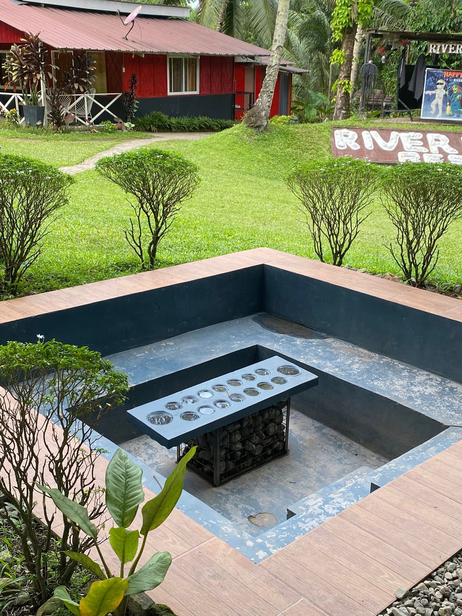 Outdoor sunken seating around a large sungka board
