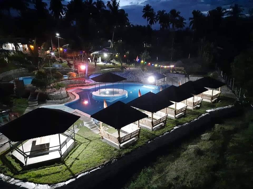 Illuminated swimming pool and rows of cottages at night