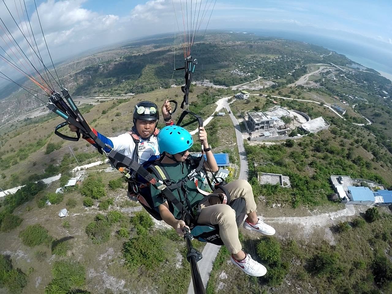Tandem paraglider flying above the Sarangani landscape