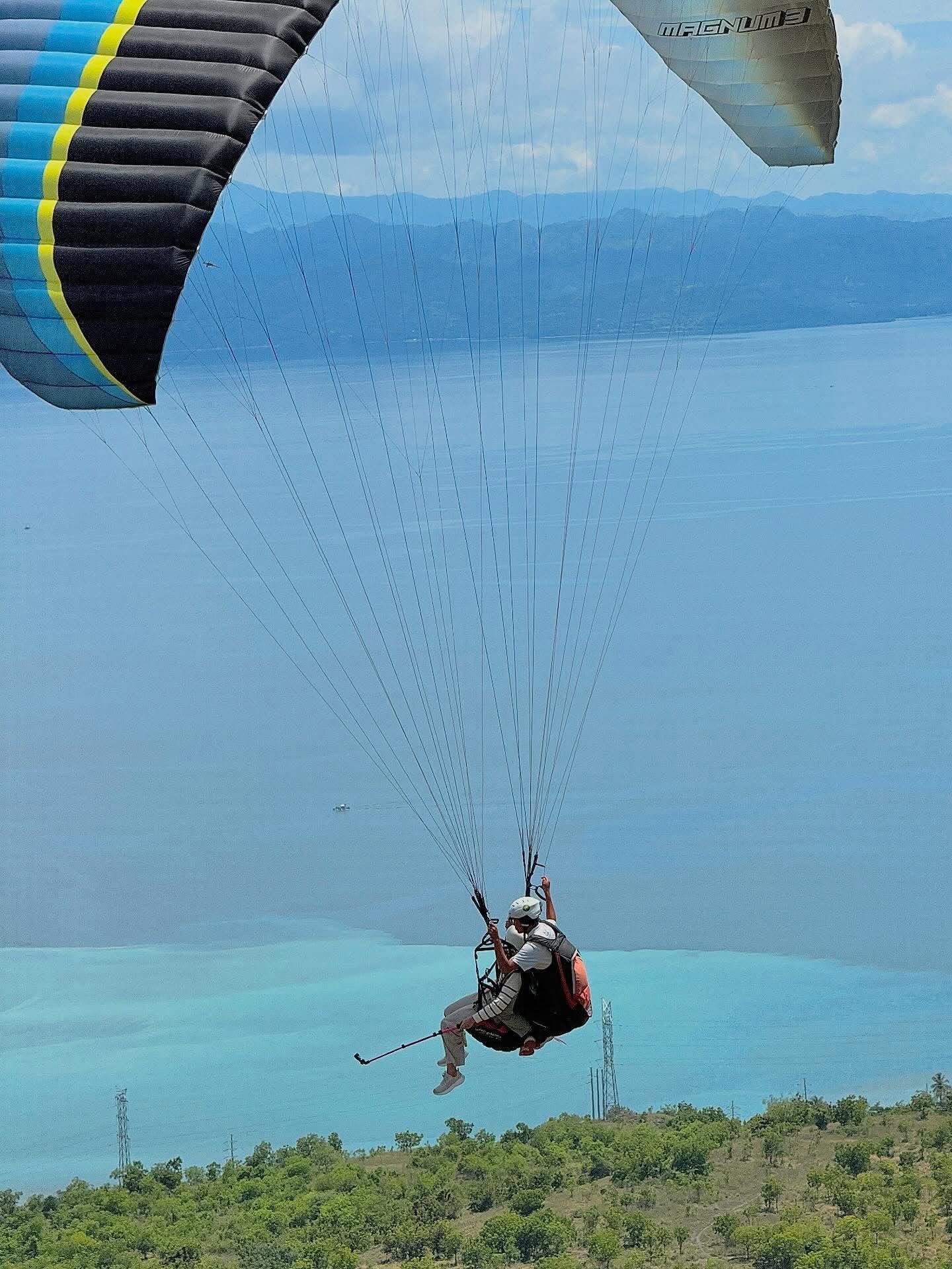 Tandem flight beneath a paraglider wing over Maasim