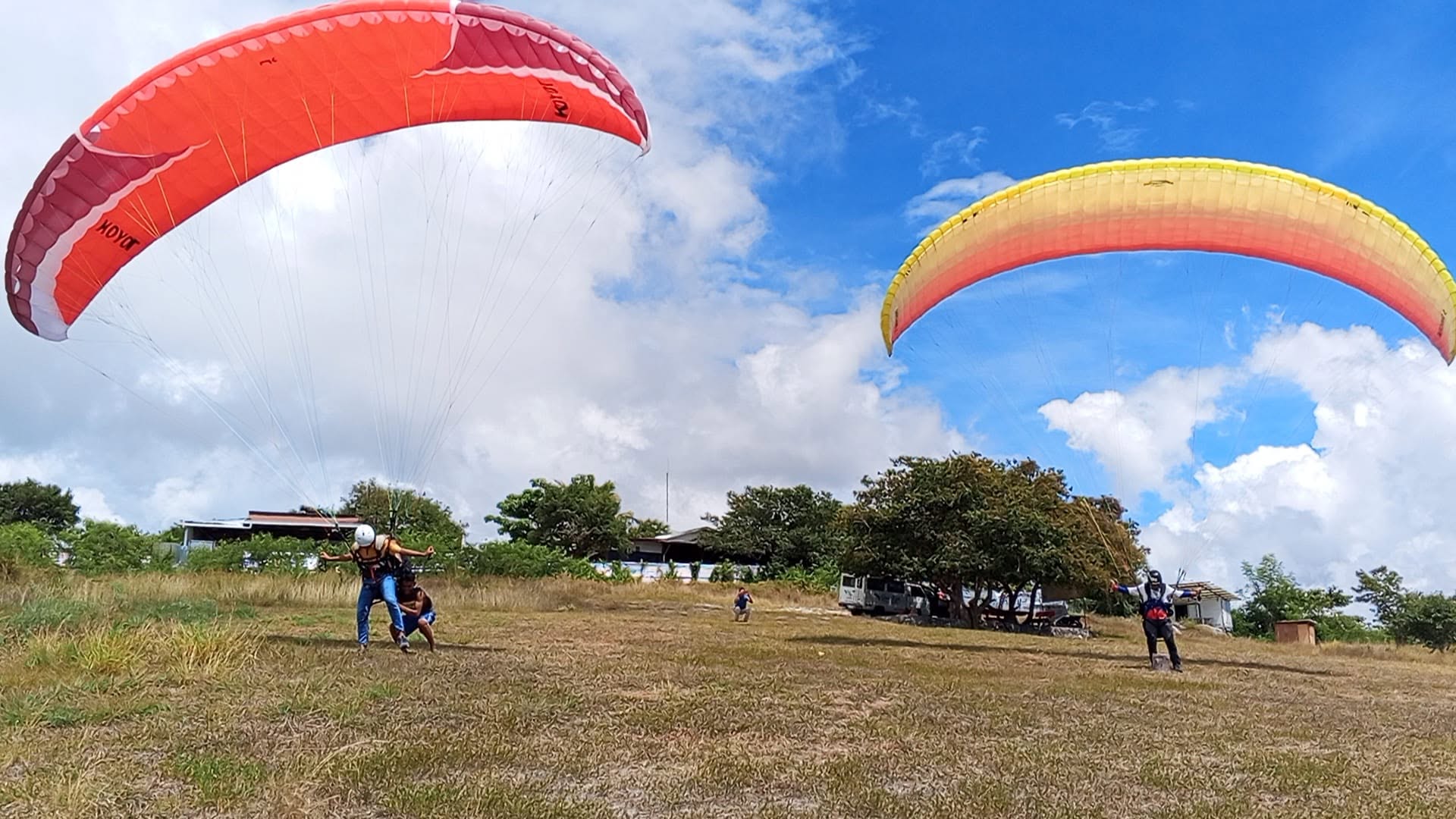 Colorful paragliders at the SAFI Ranch launch field