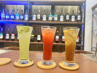 Three colorful iced drinks displayed inside the dining area