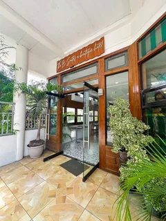 Glass entrance framed by wood and potted plants